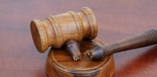 A wooden gavel resting on a circular base