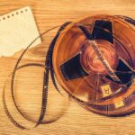 A vintage film reel with a piece of graph paper beside it