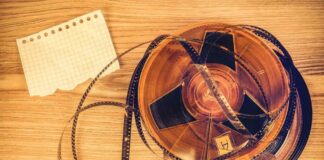 A vintage film reel with a piece of graph paper beside it