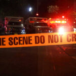 Murder Charges Against Quadruple Amputee Athlete Crime scene tape with emergency vehicles in background.