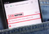 Mobile phone displaying the Live Nation website in a denim pocket