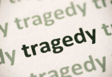 Close-up of the word 'tragedy' printed multiple times in varying shades