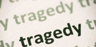 Close-up of the word 'tragedy' printed multiple times in varying shades