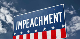 A sign displaying the word 'IMPEACHMENT' against a cloudy sky
