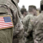 Soldiers in camouflage uniforms with American flag patches.