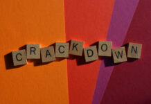 Wooden letter tiles spelling 'CRACKDOWN' on a colorful background