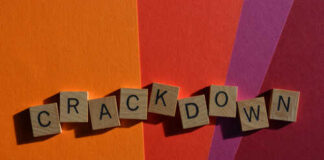 Wooden letter tiles spelling 'CRACKDOWN' on a colorful background