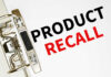 A binder clip holding a sheet of paper with the words 'PRODUCT RECALL' printed in bold letters