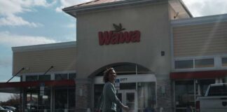 A person walking outside a Wawa convenience store