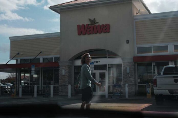 A person walking outside a Wawa convenience store