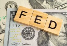 Wooden letters spelling 'FED' on top of U.S. dollar bills