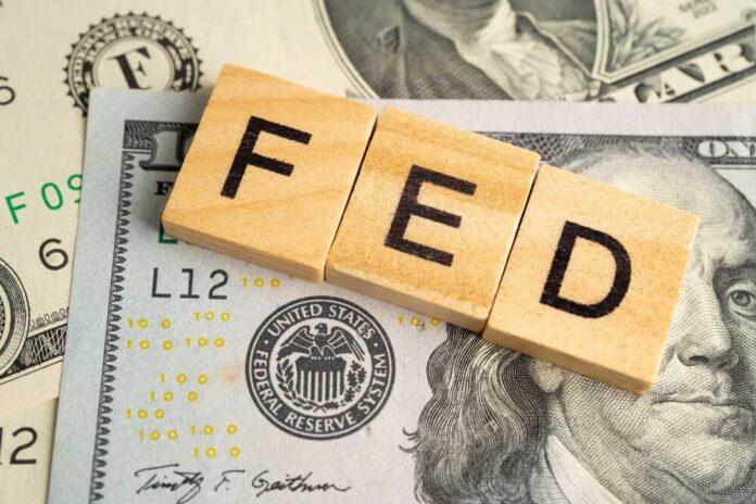 Wooden letters spelling 'FED' on top of U.S. dollar bills