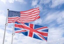 American and British flags waving against a blue sky