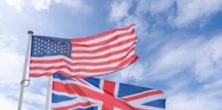 American and British flags waving against a blue sky