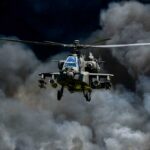 Military helicopter flying through a cloud of smoke