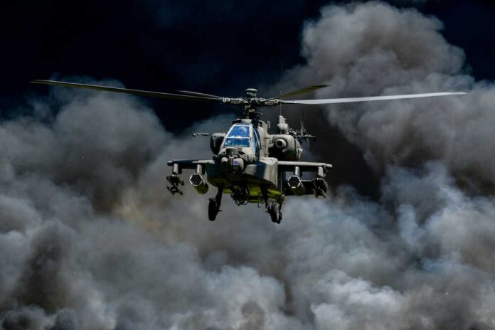 Military helicopter flying through a cloud of smoke
