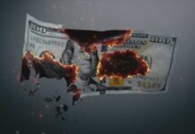 A hundred dollar bill appearing to burn and disintegrate