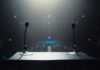 View of a podium with microphones in a dimly lit auditorium