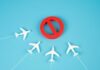 A red prohibition sign surrounded by white airplane models on a blue background