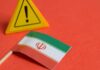 Iranian flag next to a caution sign on a red background