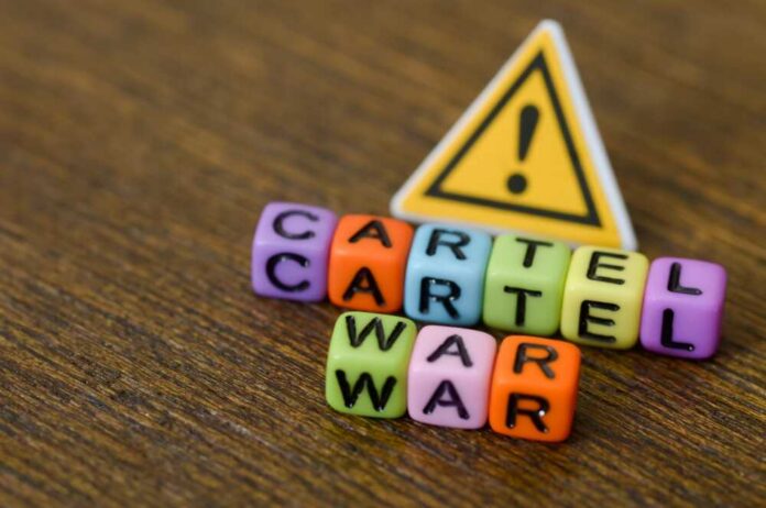 Colorful letter blocks spelling 'CARTEL' and 'WAR' with a warning sign