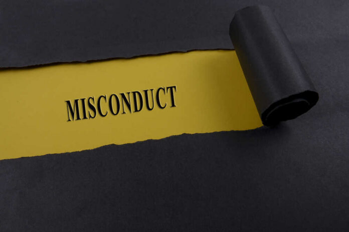 Torn black paper revealing the word 'MISCONDUCT' on yellow paper