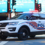 Emergency Curfew Sparks Controversy Police SUV with lights on in an urban environment