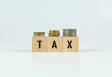 Bezos Drops Tax Bombshell: Pay Zero Plan! Blocks spelling 'TAX' with coins stacked beside them