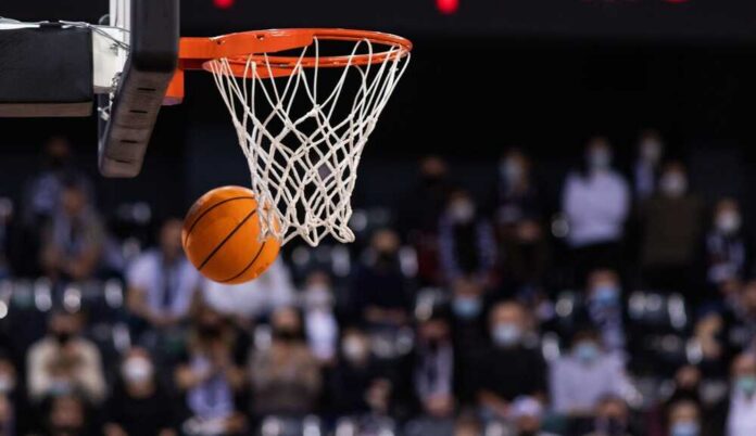 shutterstock_2121289172.jpg A basketball is about to enter the hoop during a game