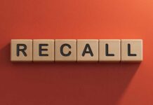 The word 'RECALL' displayed in wooden letter blocks against a red background