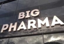 Sign displaying the words BIG PHARMA on a glass building