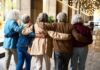 DANCE SURPRISE: Seniors Gain Super Strength! Group of elderly friends walking arm in arm outdoors