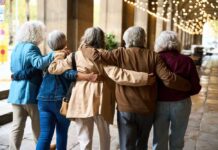 DANCE SURPRISE: Seniors Gain Super Strength! Group of elderly friends walking arm in arm outdoors