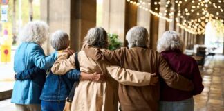 Group of elderly friends walking arm in arm outdoors