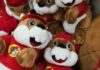 A collection of plush toys resembling a cartoon character, wearing red outfits