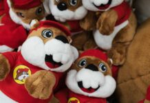 A collection of plush toys resembling a cartoon character, wearing red outfits