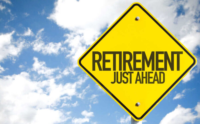 A yellow road sign indicating retirement is just ahead