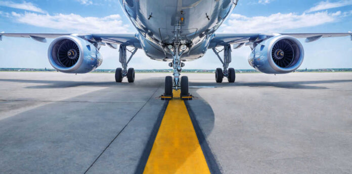 Airplane on runway with visible landing gear engines