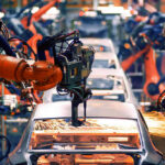 STUNNING Loss: EV Strategy Crumbles Robotic arms welding car bodies in an automotive factory.