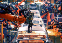 STUNNING Loss: EV Strategy Crumbles Robotic arms welding car bodies in an automotive factory.