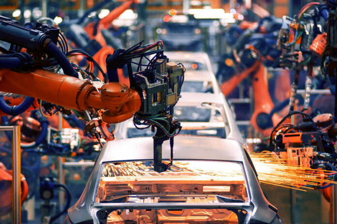shutterstock_732734518 Robotic arms welding car bodies in an automotive factory.