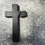 Broken black cross on a gray surface.