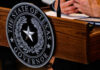 Texas Mandate Sparks Church-State Battle Seal of Texas Governor on wooden podium.