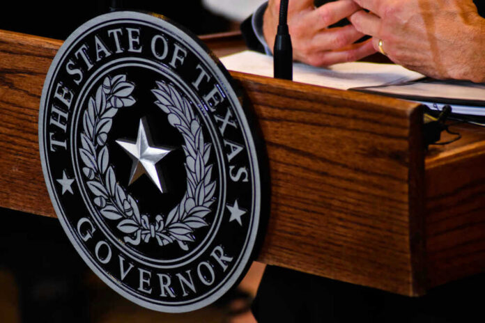 Seal of Texas Governor on wooden podium.