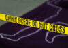 Yellow crime scene tape marking off an area with a chalk outline