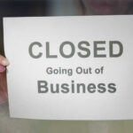 Fast-Food Shock: 59 Burger Joints in Turmoil A person holding a sign that reads 'CLOSED Going Out of Business'