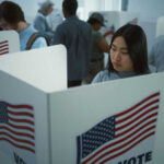 Map Flip Triggers 5-1 Voting Change People voting in booths with American flags.