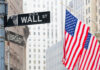 Street signs for Wall Street and Broad Street with American flags