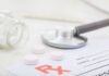 Mystery Gunk Triggers Massive Pill Recall A stethoscope, prescription pad, and pink tablets on a table