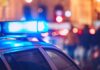 Chilling Find Near Gym — ID Of Dead Body Still Pending Close-up of a police car with blue emergency lights in a city at night